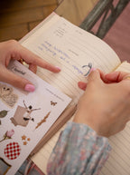 Dziewczyna nakleja naklejki w pamiętniku