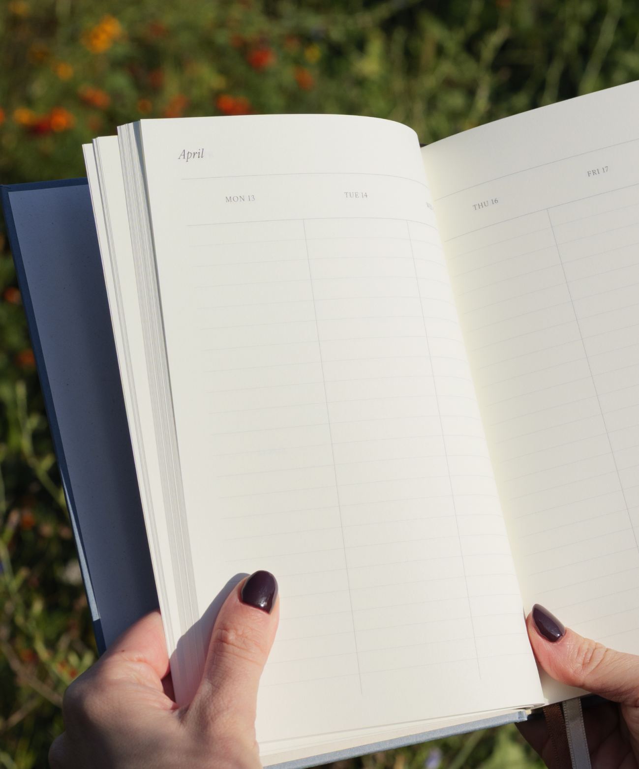 Niebieski kalendarz 2026 kartkowany na tle zieleni