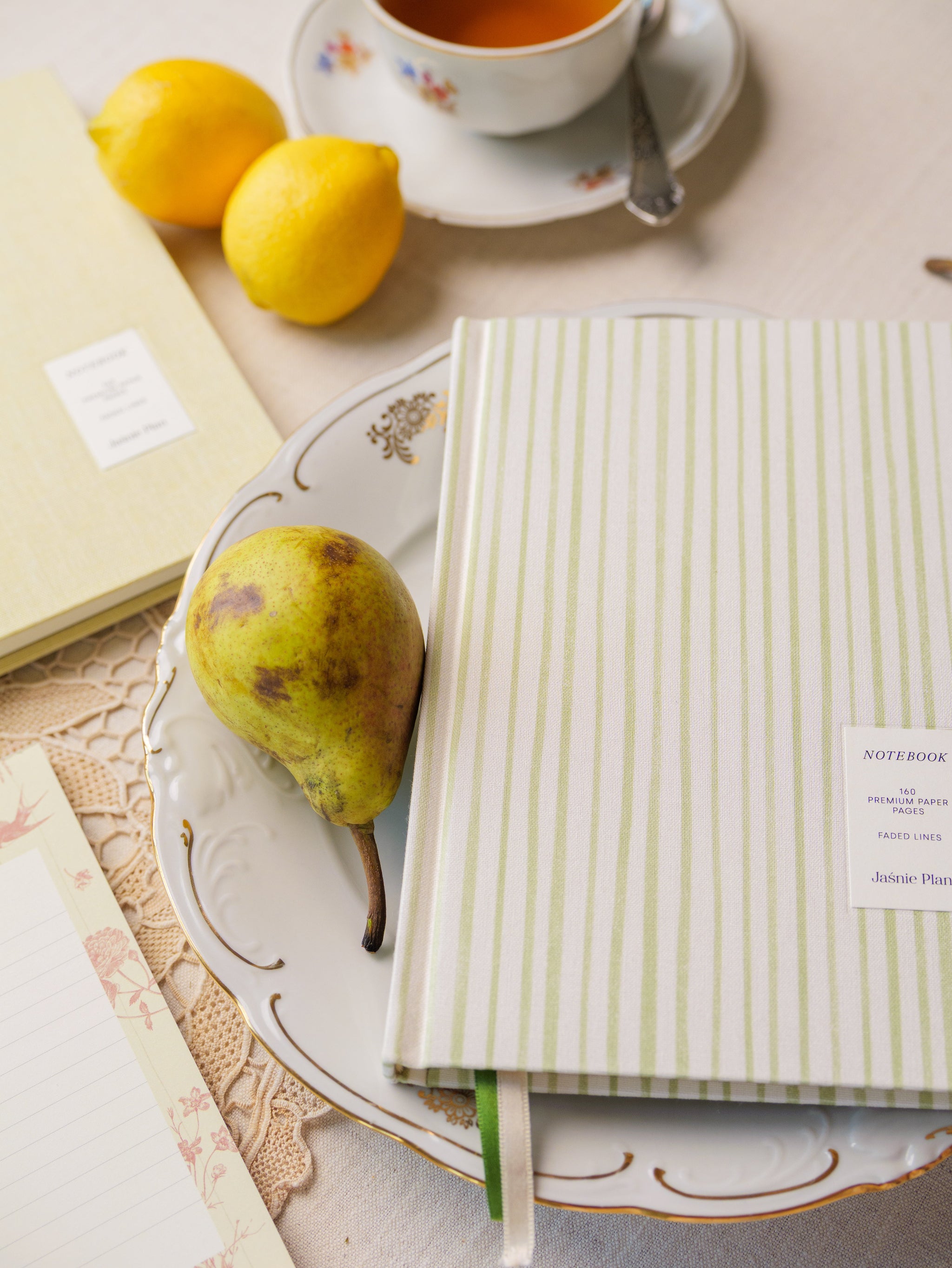 Notesy Polny i Słonecznikowe na stole z gruszką i cytrynami