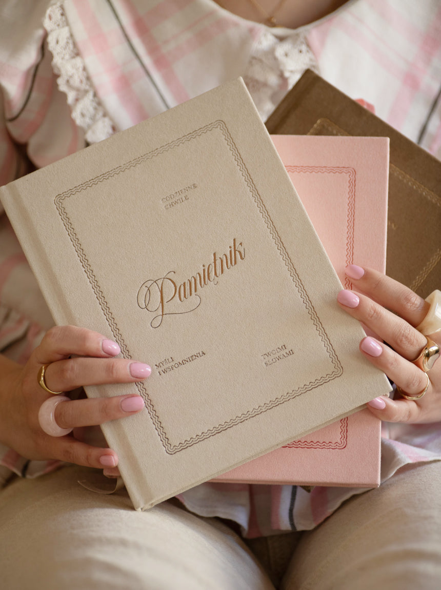 Beżowy, welurowy pamiętnik Jaśnie Planu w stylu vintage trzymany przez modelkę