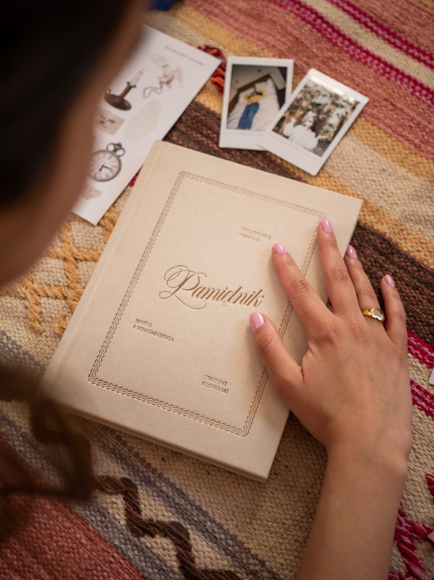 Pamiętnik beżowy leżący na kolorowym dywanie