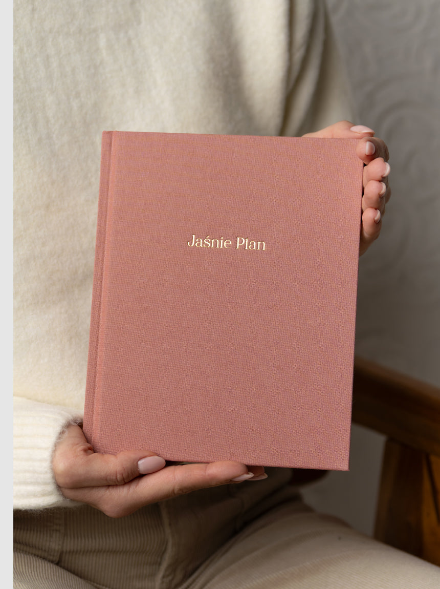 Dziewczyna przedstawiająca różowy planer Jaśnie Plan