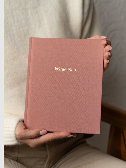 Dziewczyna przedstawiająca różowy planer Jaśnie Plan