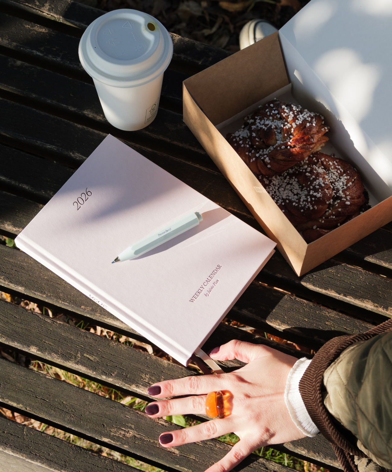 Różowy kalendarz z dlugopisem Kaweco na ławce